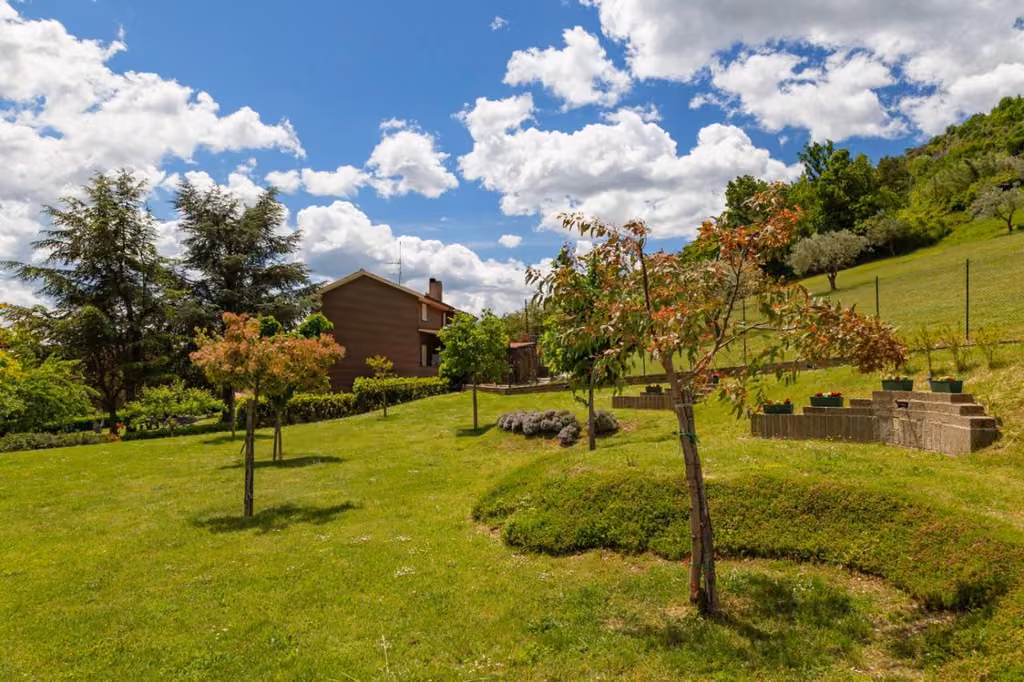 Giardino della tenuta con gli alberi e lo spazio per i tavoli
